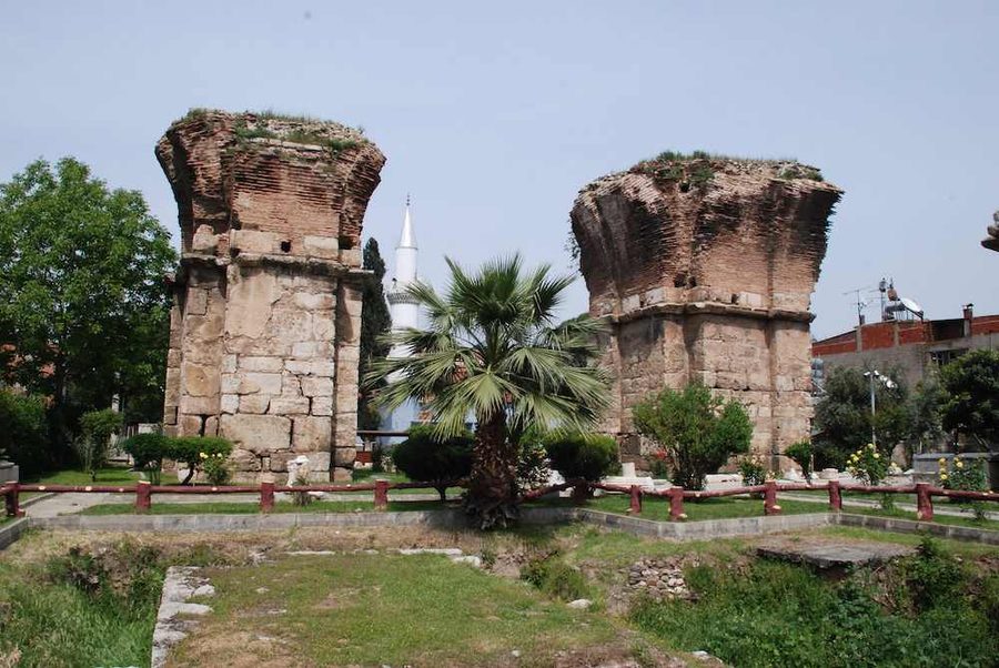 Two of the great brick-and-stone pillars of the Basilica of St John in Alaşehir, ancient Philadelphia, with a minaret rising between them